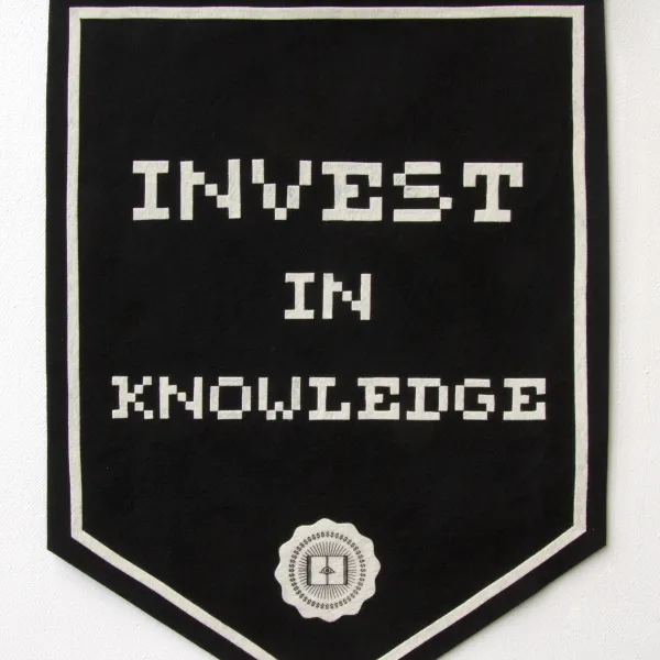 Black flag with the text "Invest in knowledge" written on it and a logo below