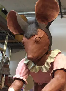 Photo of terra cotta mouse head being added to in-progress statue