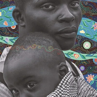 A black faather holding his child on a painting of colorful ribbons of various fabric textures
