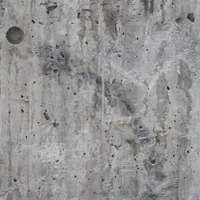 Photo of a concrete wall covered in water stains and pock marks
