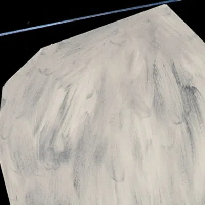 Large roundish boulder-shaped image, white with streaks of gray, and a blue diagonal ray coming from the left to connect with the point at the top of the "boulder".