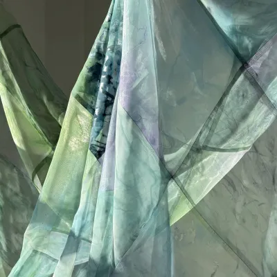 Sunlight passing through sheer blue and green fabric