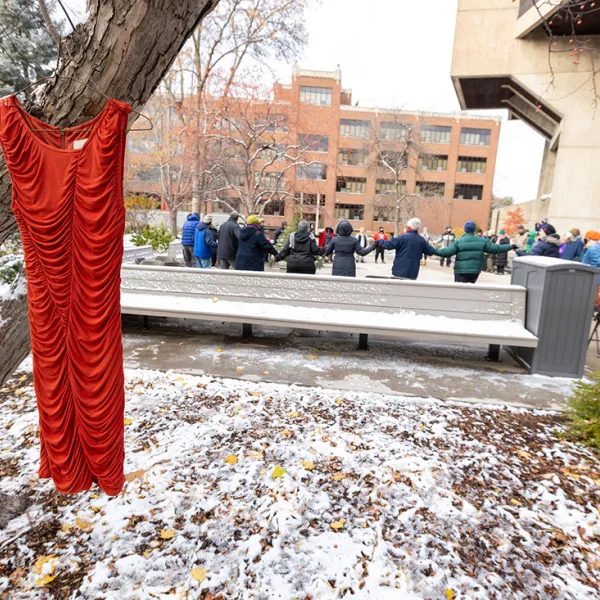 Red dress hung on tree on campus