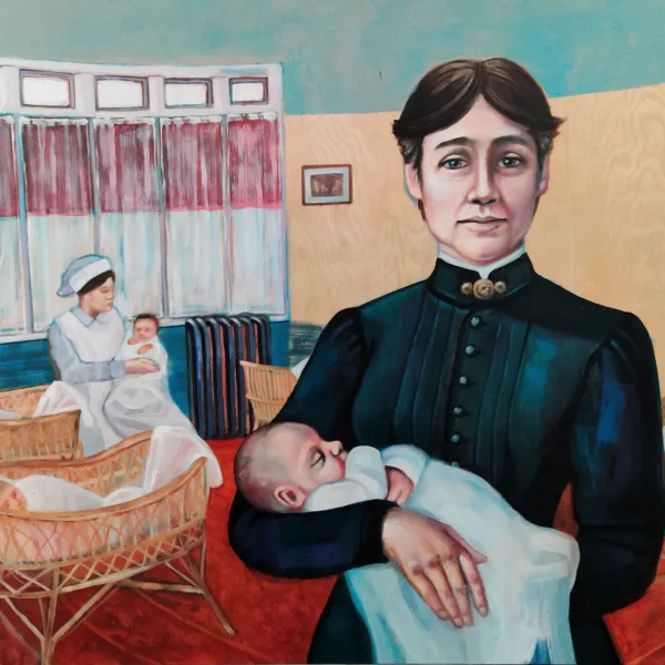 Portrait of Dr. Martha Rogers Ripley standing in a nursery holding a baby.