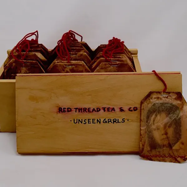"Red Thread Tea: Unseen Grrls," Bamboo tea box, 30 photos in tea bags, cotton red thread, 8” x 4.25” x 3.5”