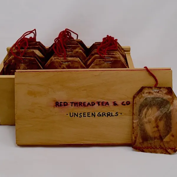 Araela Kumaraea "Red Thread Tea: Unseen Grrls," Bamboo tea box, 30 photos in tea bags, cotton red thread, 8” x 4.25” x 3.5”