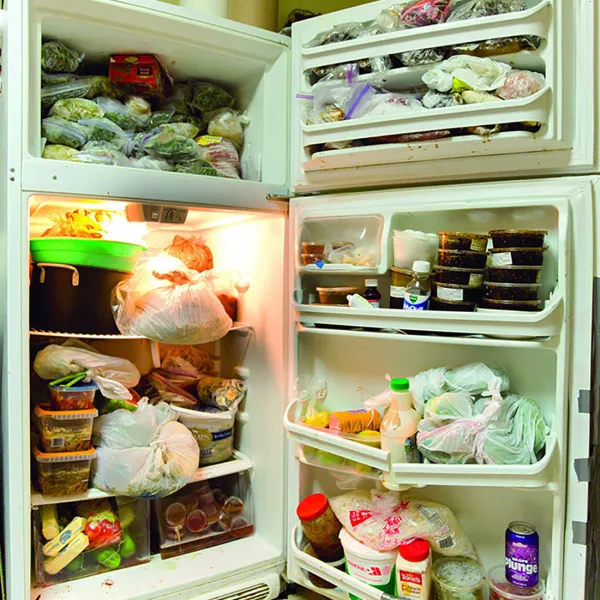 A large refrigerator with the refrigerator and freezer doors open, displaying their contents.