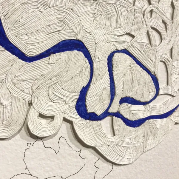 Close-up of coiled paper with a blue line wandering through it (like a river on a map).