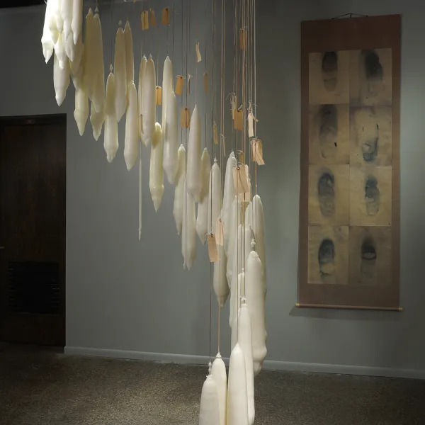 The Art of Losing Isn’t Hard To Master, 2015, wax on string background: Ghost II, 2015, digital print on handmade Bhutan paper mounted on Thai silk sateen, 94” x 31.5”