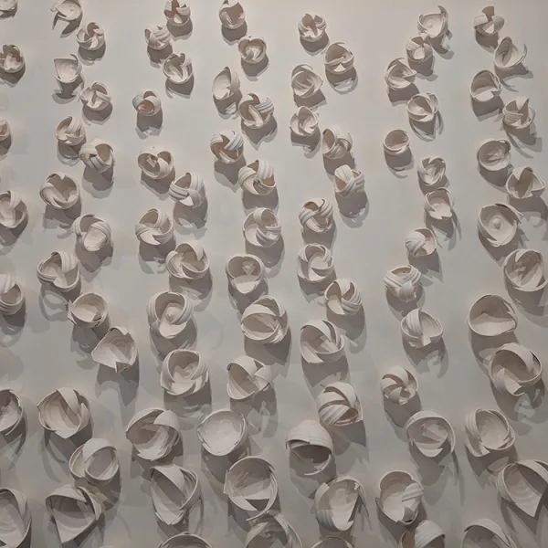 Monica Rudquist, Dancing Vines Many small sculptures made of pieces of bowls, laid out in a vine-like pattern.