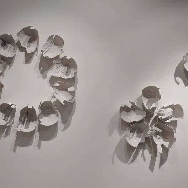 Monica Rudquist, Floating Wall Three wall sculptures made of pieces of bowls, like lily pads - one large circle, one small circle, and one five-petaled flower.