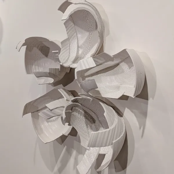 Monica Rudquist, Floating Wall Detail 1 Abstract wall sculpture made of pieces of bowls, in the shape of a five-petaled flower.