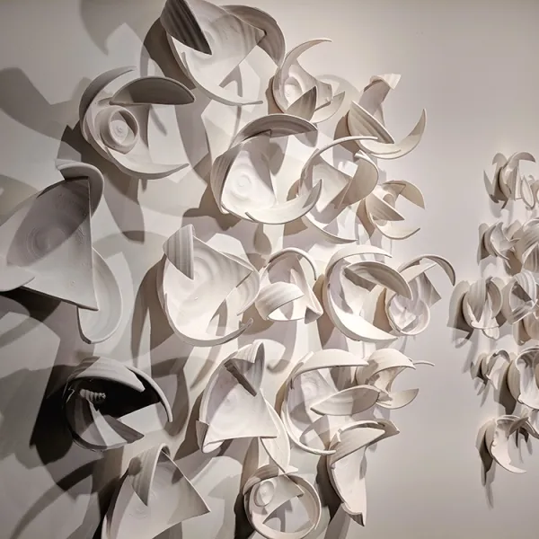 Monica Rudquist, Winged Abstract wall sculpture made of pieces of bowls, constructed so they give the impression of wings.