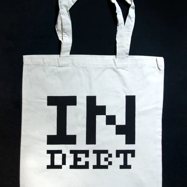 White Swag Bag with "IN DEBT" written in black on it