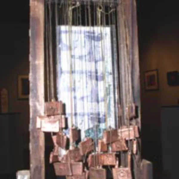 A metallic doorway with many rectanble metal sheets hanging from strings over the entryway.