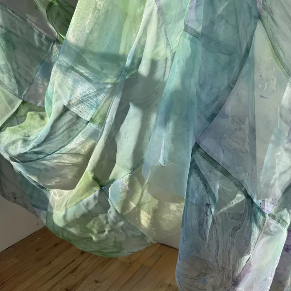 Sunlight passing through sheer blue and green fabric