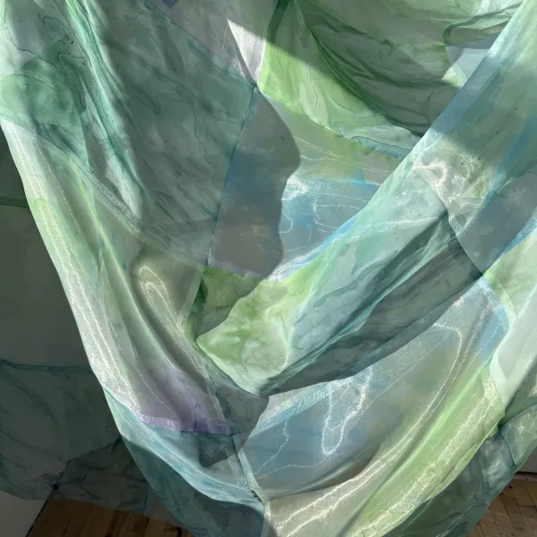 Sunlight passing through sheer blue and green fabric