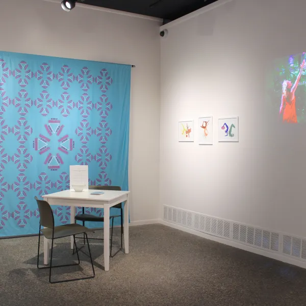 Sisters of Shakti; Interactive installation, table with postcards, a bowl of lollipops and a stamp, two chairs, fabric banner, poster on signboard