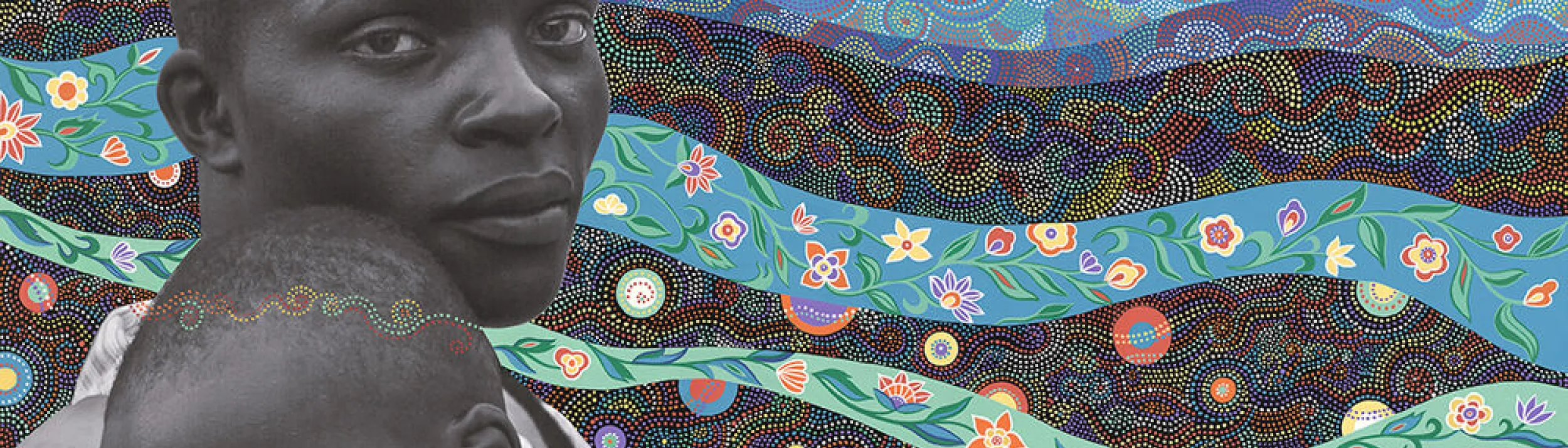 A black faather holding his child on a painting of colorful ribbons of various fabric textures