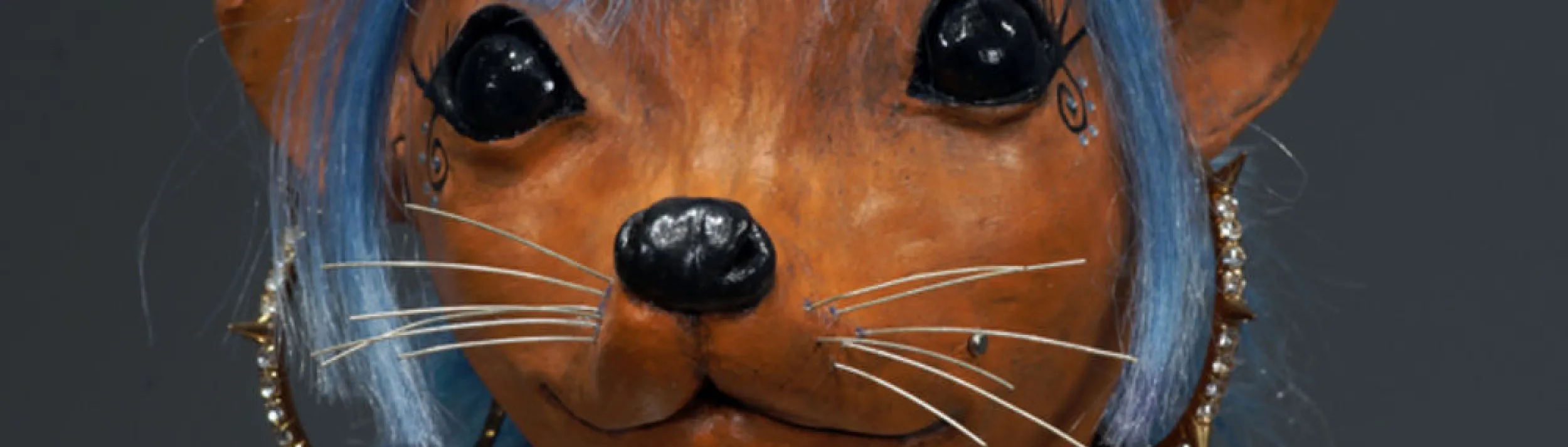Close-up photo of a terra cotta figurine of an animal person dressed up in a goth punk style
