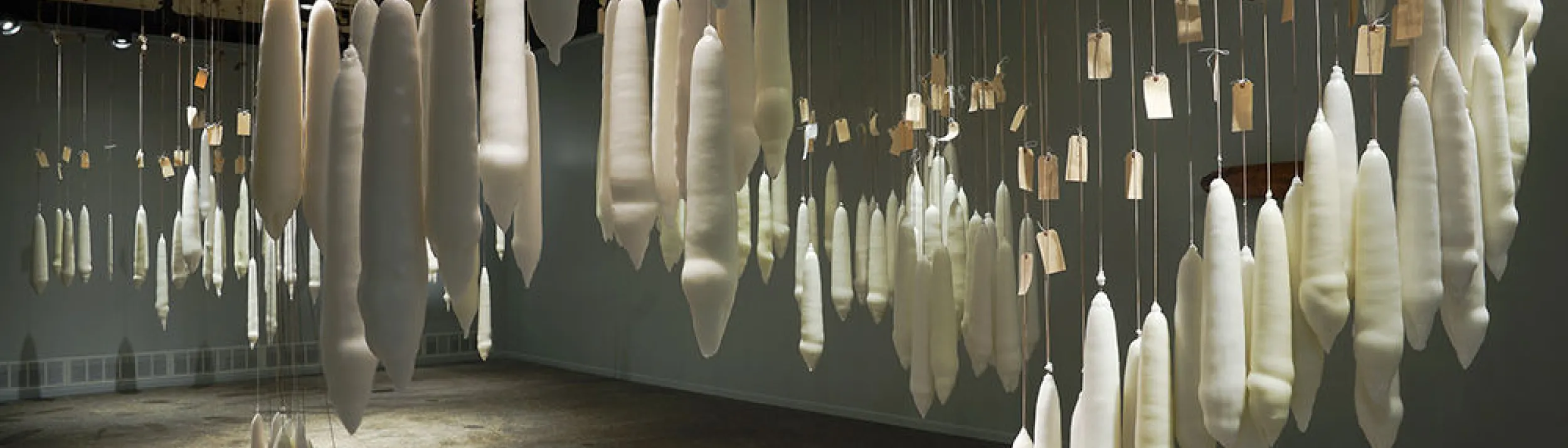 A large collection of candles dipped the same number of times as the lifespans of people attached to them; they hang from the cieling in various arrangements.