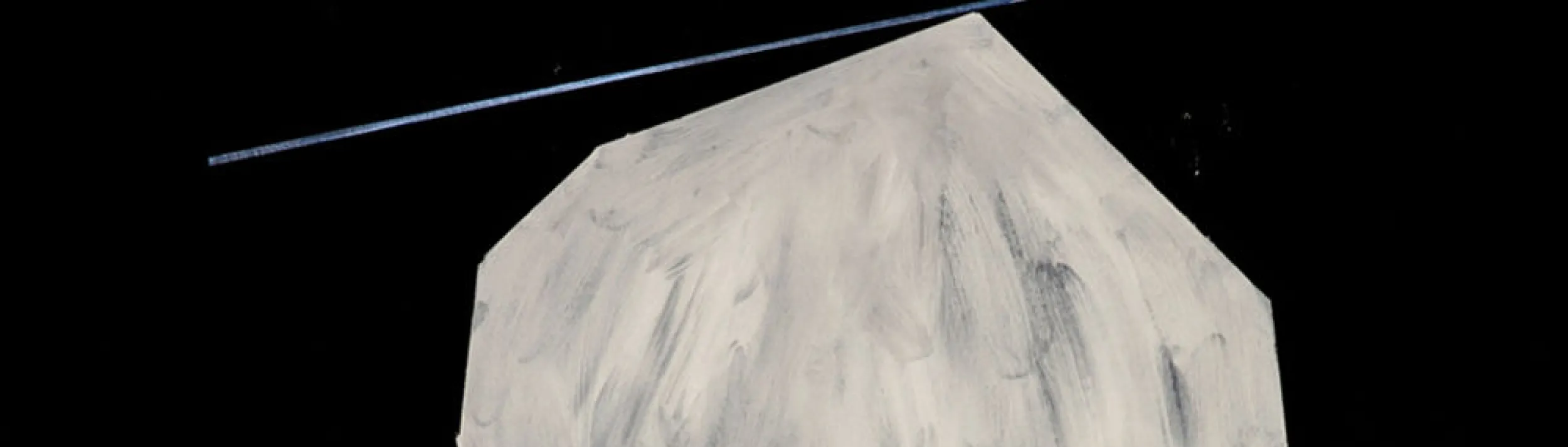 Large roundish boulder-shaped image, white with streaks of gray, and a blue diagonal ray coming from the left to connect with the point at the top of the "boulder".