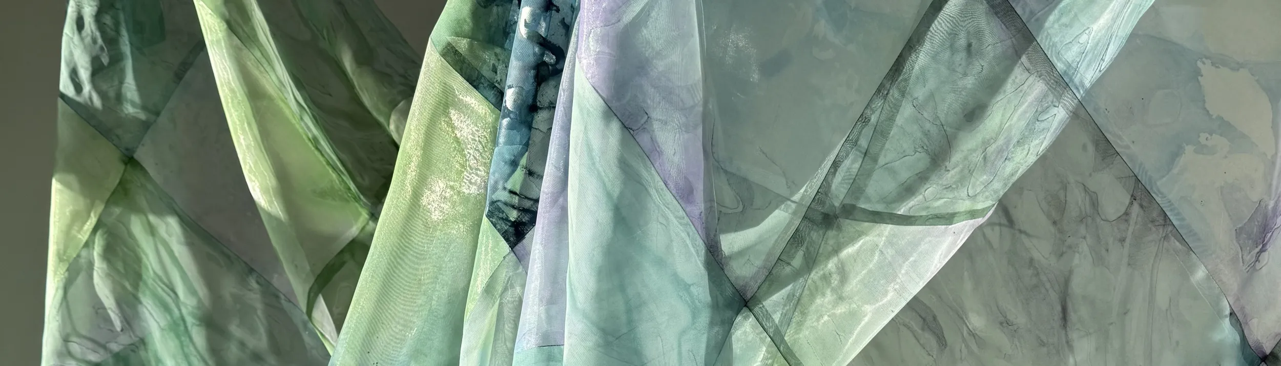 Sunlight passing through sheer blue and green fabric