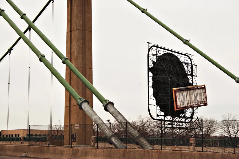 Detail of suspension bridge supports, rear of billboard in background