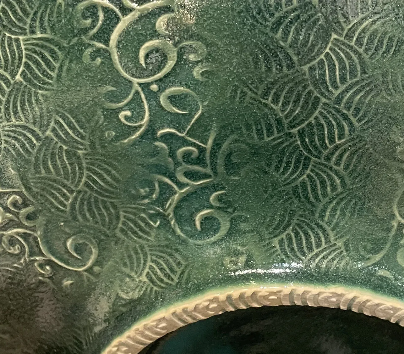 "Braid-Curlicue (detail)" - A close-up for finely etched ceramic with a deep green glaze